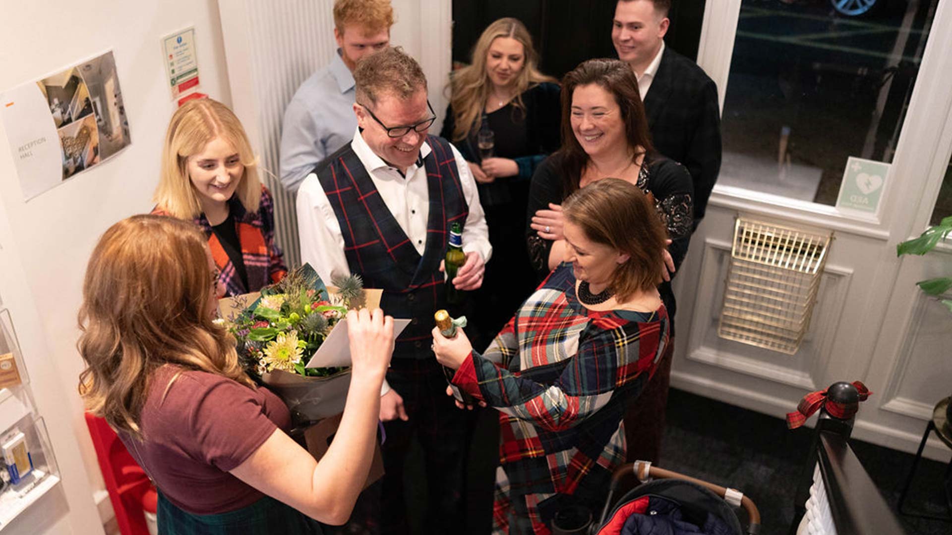 a group giving out flower and wine for celebration